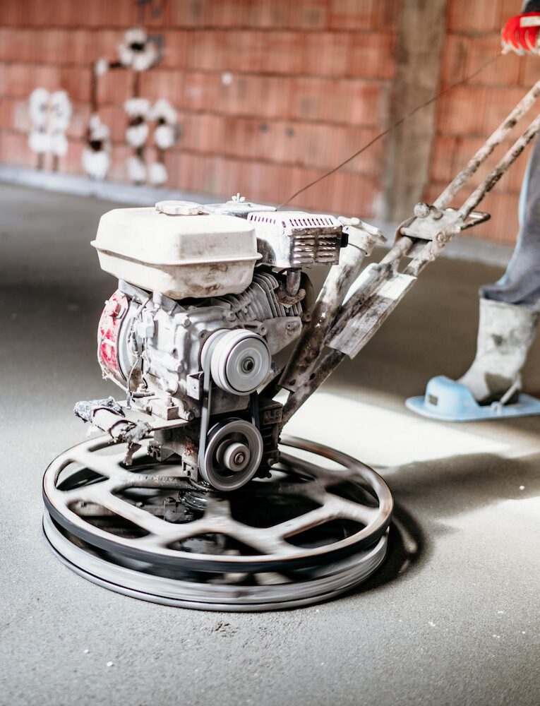 Worker with power trowel tool finishing concrete floor, screed, smooth concrete surface Waku Sanitär und Heiztechnik Bad sanierung